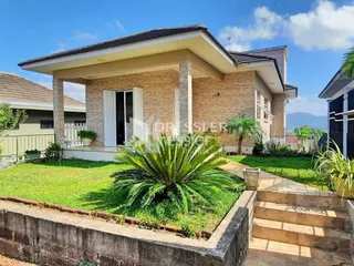 A fachada de uma casa em Lajeado, Brasil, com jardim gramado e muro de pedra.
