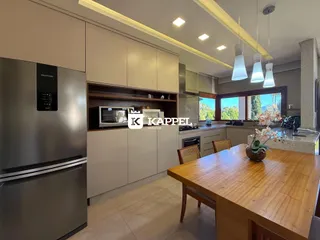 Foto de uma cozinha moderna com armários brancos e bancada de madeira clara.