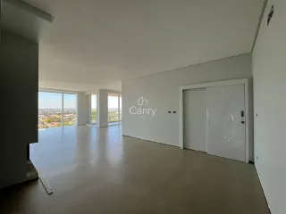 Sala ampla com grandes janelas oferecendo uma vista panorâmica da paisagem urbana.