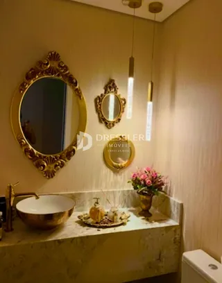 Mesa de banheiro com bancada de mármore e espelhos decorativos.