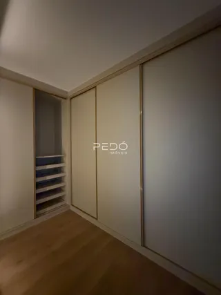 Interior de um corredor com armários embutidos e piso de madeira.