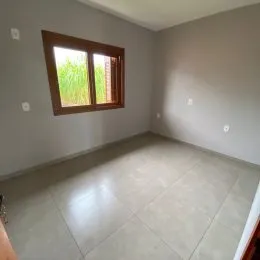 Vista de uma janela em um cômodo interno com piso de cerâmica.