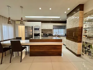 Cozinha moderna com ilha de madeira e bancadas.