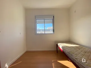 Quarto com piso de madeira e janela.
