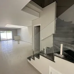 Hall de entrada com paredes brancas e piso claro.