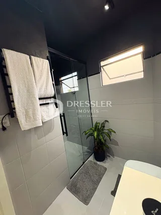 Foto de um banheiro moderno com azulejos cinzas e uma janela.