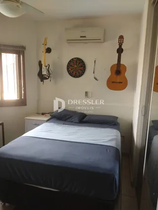Foto de um quarto com cama e instrumentos musicais na parede.