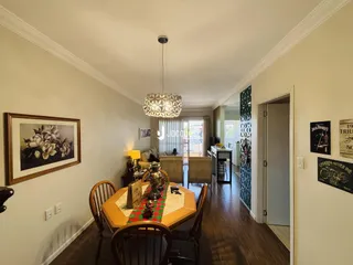 Interior de uma sala de jantar com piso de madeira e decoração de parede.