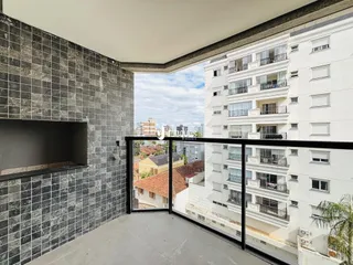 Vista de um terraço com grade preta em um edifício residencial.