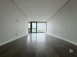 Interior amplo com paredes brancas e piso cinza.