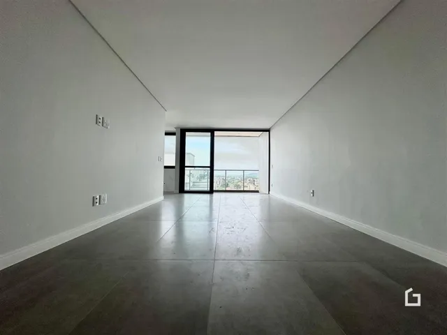 Interior amplo com paredes brancas e piso cinza.
