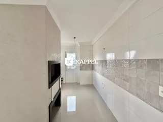 Foto do corredor interno de um apartamento com revestimento de azulejos claros.