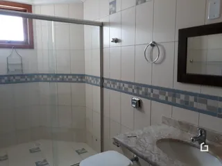 Foto de um banheiro com revestimento cerâmico e bancada.