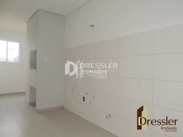 Corredor interno de uma residência com paredes brancas.