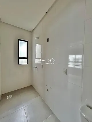 Corredor interno com paredes brancas e piso claro.