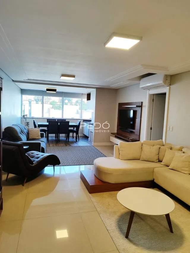 Sala de estar com sofá e piso claro em um imóvel no Brasil.