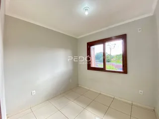 Quarto interno com paredes brancas e piso de cerâmica claro.