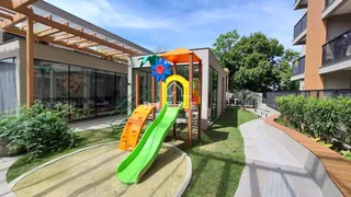 Área externa com playground e gramado de uma residência moderna.