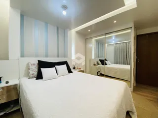 Quarto com cama e painel decorativo em ambiente claro.