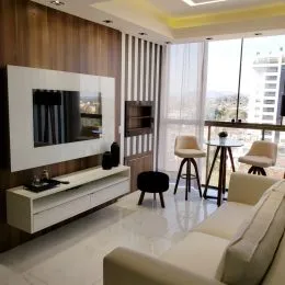 Sala de estar com televisão de tela plana e móvel branca.