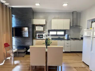 Sala de estar e cozinha com lareira em um imóvel em Lajeado.