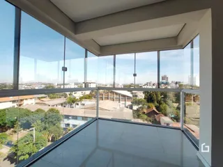 Vista de um ambiente com grandes janelas de vidro.