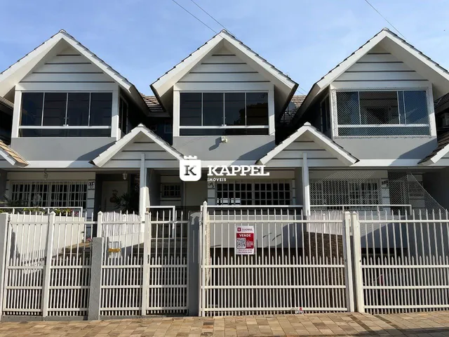 Fachada de uma casa moderna em Lajeado, Brasil, com cerca branca e portão.