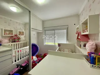 Quarto interno com móveis brancos e decoração infantil.