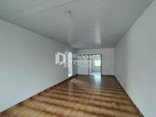 Corredor interno com piso de madeira em uma residência.
