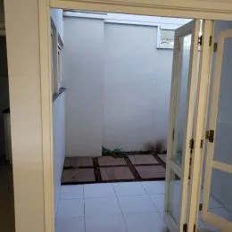 Vista interna de um ambiente com paredes brancas e piso de cerâmica.