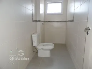 Foto de um banheiro com revestimento cerâmico branco.