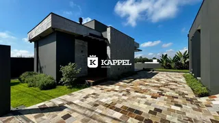 Fachada externa de uma casa moderna com piso de ladrilhos na área externa.