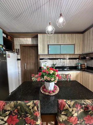 Foto de uma cozinha com armários de madeira e bancada escura.