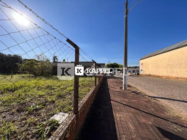 Vista externa de uma cerca e estrada de acesso em uma propriedade.