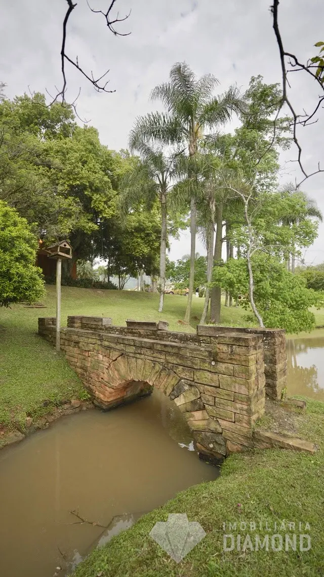Ponte de pedra sobre um riacho verde em uma propriedade no Brasil.