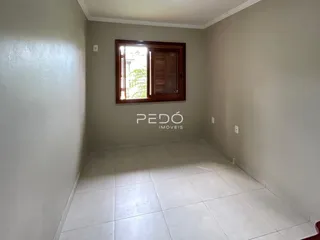 Vista interna de um ambiente com piso de cerâmica e uma janela.