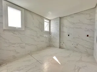 Interior de um cômodo com revestimento em mármore claro nas paredes e piso.