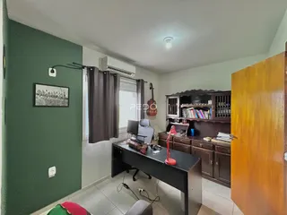 Ambiente interno com paredes verdes e móveis de madeira em um imóvel no Brasil.