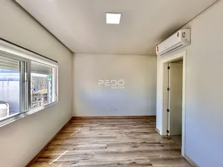 Sala de estar com piso de madeira e janela.