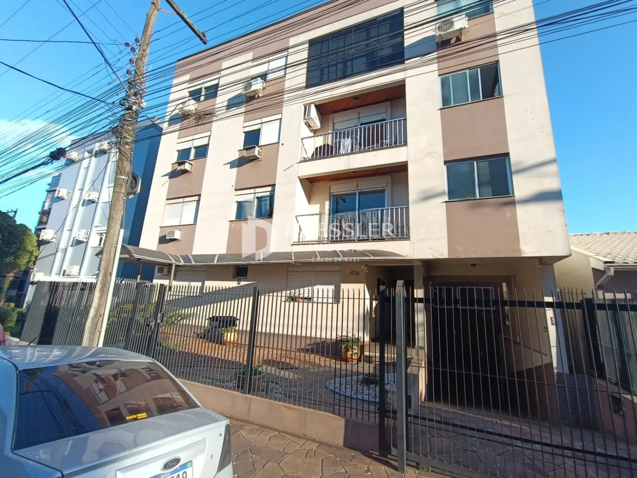 Fachada de um prédio residencial em Lajeado, Brasil, com varandas e grade de segurança.