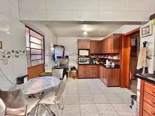 Ambiente de sala de jantar e cozinha com armários de madeira em Lajeado.