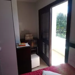 Quarto com armário escuro e porta de vidro na lateral.