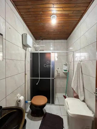 Foto de um banheiro com revestimento de azulejos brancos e teto de madeira.