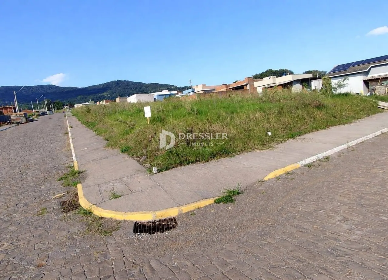 Vista externa de um lote com vegetação e calçada no Brasil.