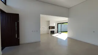 Ambiente interno com paredes brancas e piso claro, com acesso a uma área externa.