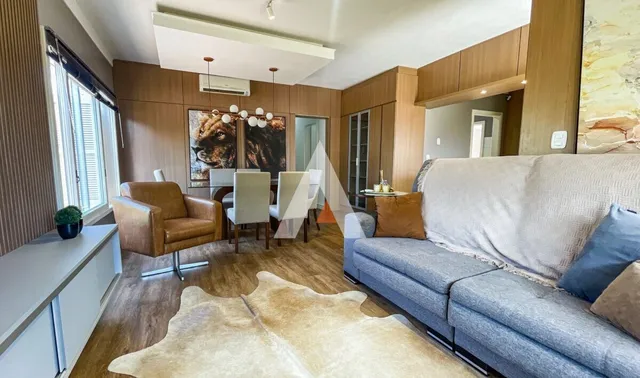Sala de estar com sofá e piso de madeira em um imóvel.