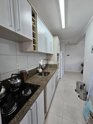Cozinha moderna com armários brancos e bancada de granito.
