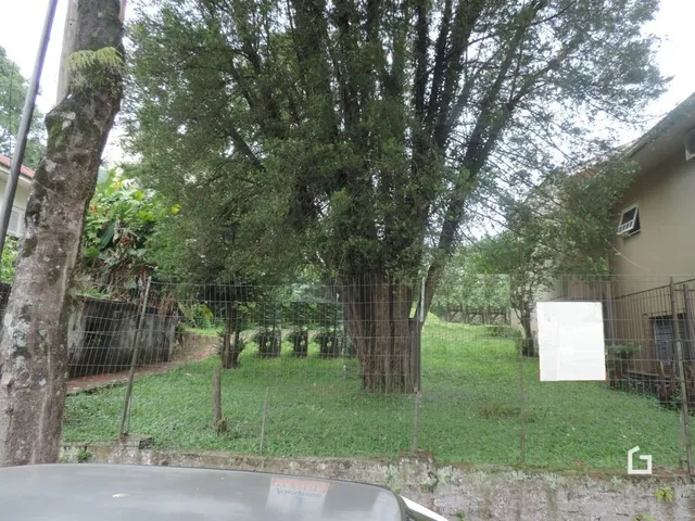 Vista externa de um terreno com vegetação e cerca.
