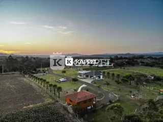 Vista aérea de uma propriedade rural com vegetação e área aberta.