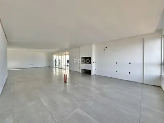 Ambiente interno amplo com piso de concreto claro.